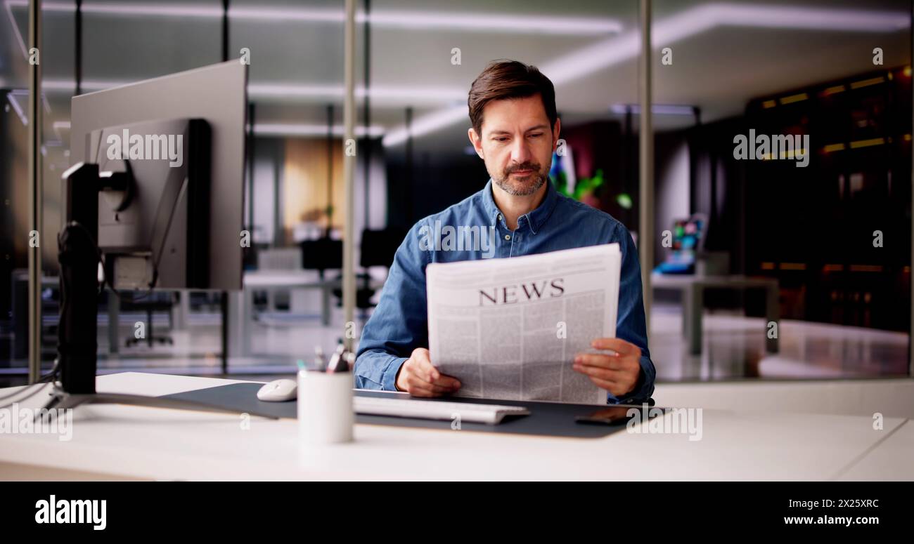 Geschäftsmann Liest Zeitung Am Schreibtisch Auf Der Arbeit Stockfoto