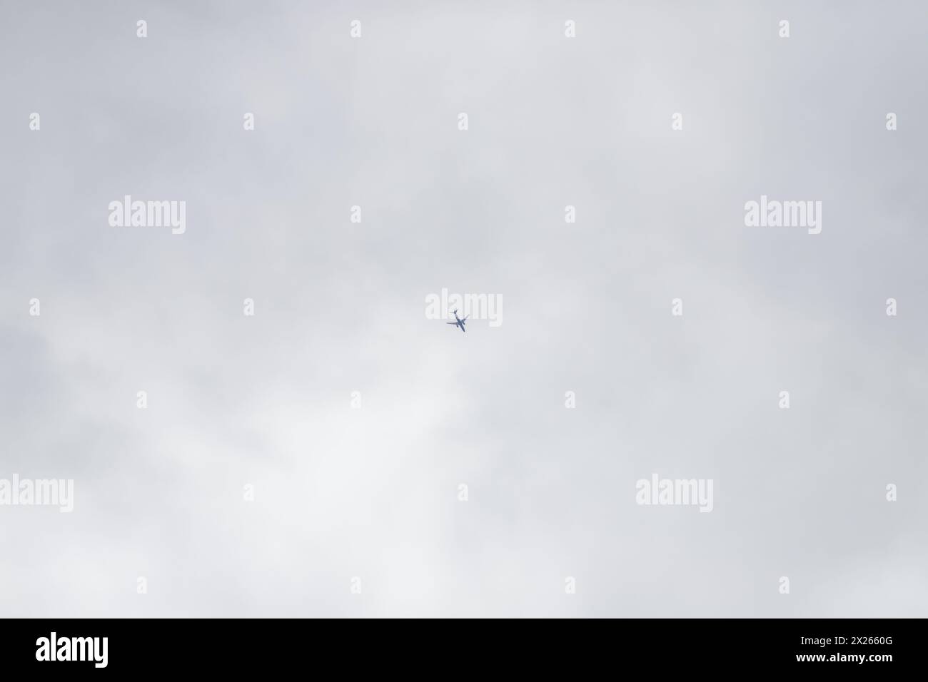 Passagierflugzeug am Himmel etwas unter den Wolken Stockfoto