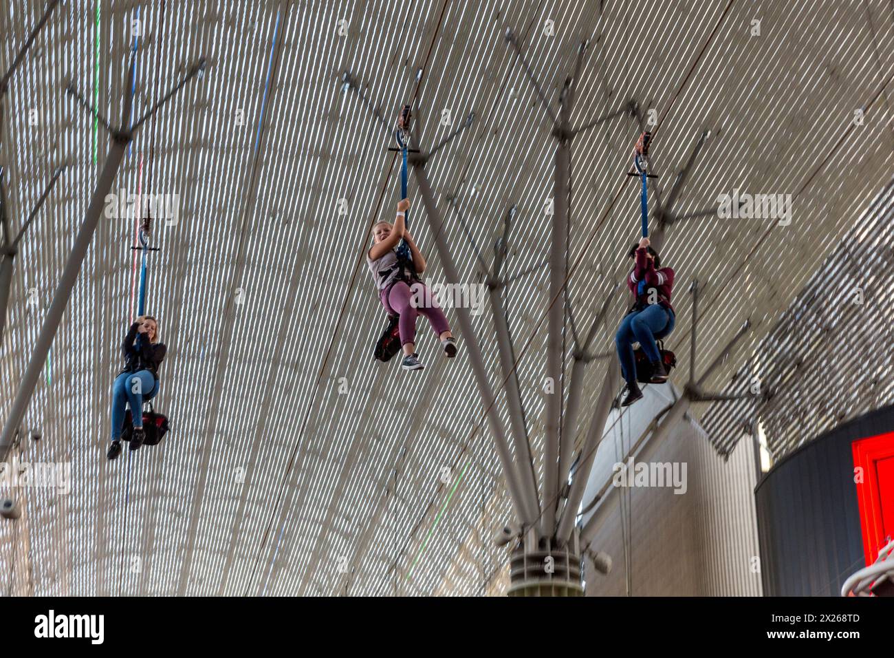 Las Vegas, Nevada.  Fremont Street.  Drei junge Frauen reiten SlotZilla Zipline. Stockfoto