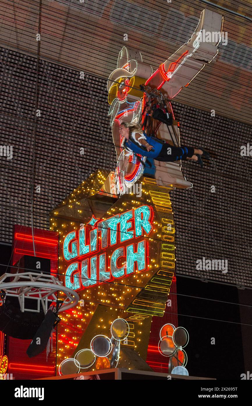 Las Vegas, Nevada.  Fremont Street.  Glitter Gulch Cowgirl Schild, mit Zoomline-Reiterin, die letzten gehen auf die Zip-Line. Stockfoto