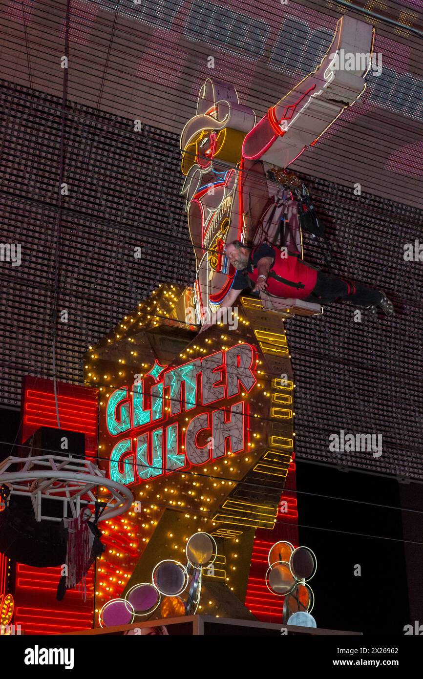 Las Vegas, Nevada.  Fremont Street.  Glitter Gulch Cowgirl Schild, mit Zoomline Zip Line Rider gehen Vergangenheit. Stockfoto