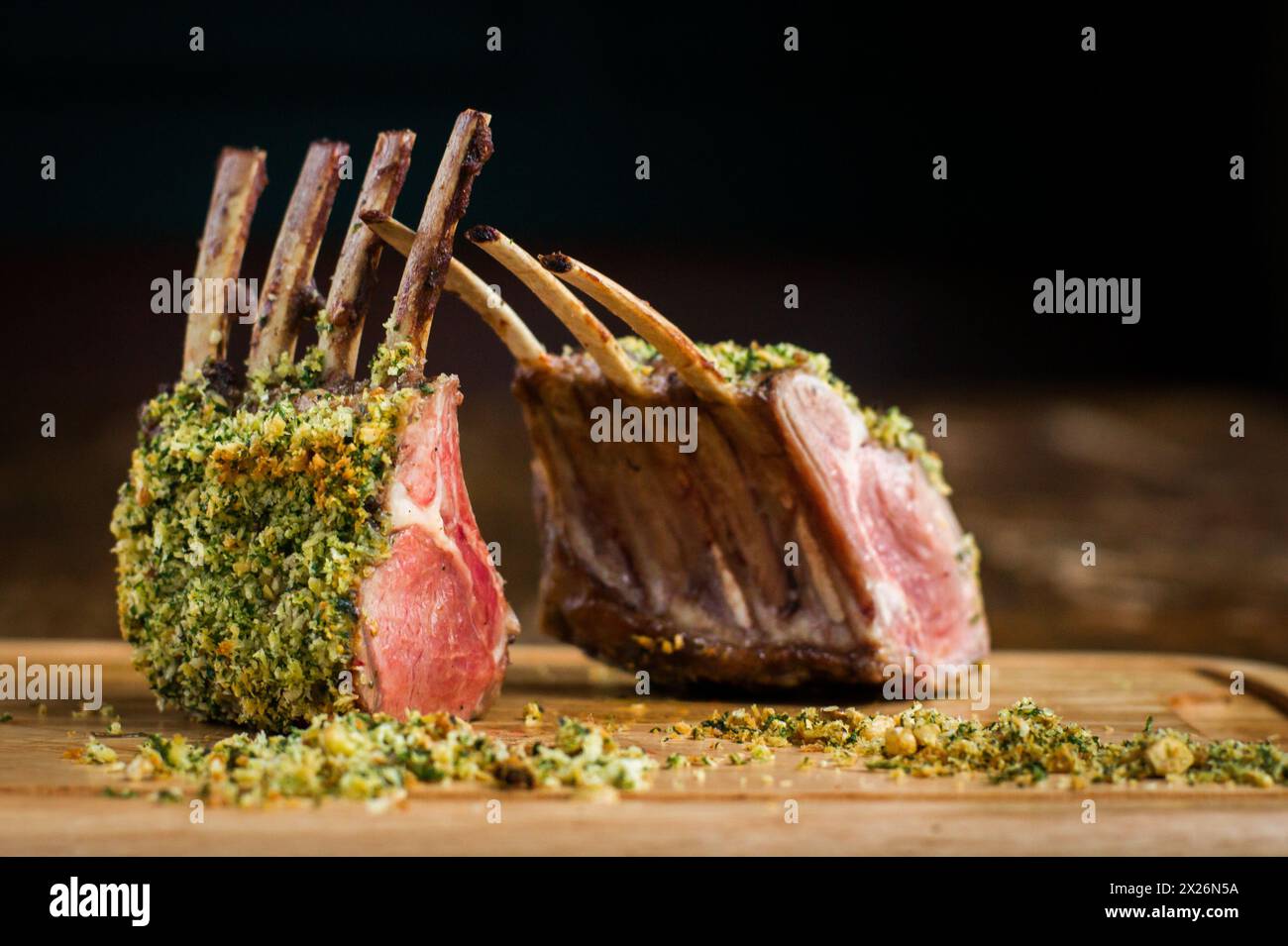 Gekochtes Lammregal mit Haselnusskruste auf Holzbrett im Restaurant Stockfoto