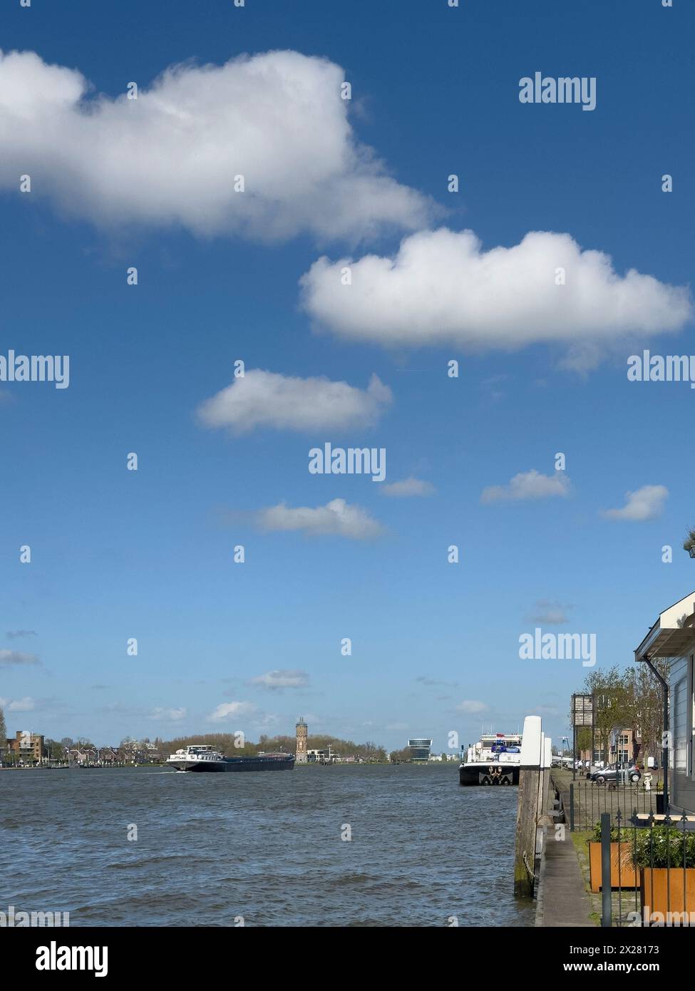 Binnenschiffsfrachttransport, der an Dordrecht in Holland in den Niederlanden vorbeifährt, auf dem ruhigen Flusswasser der Maas. Containerschiff Trans Stockfoto