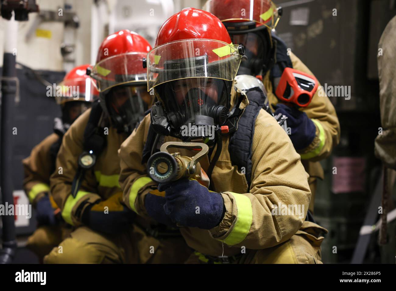 240412-N-MQ781-1095 (11. April 2024) Bay of Cadiz – Matrosen bekämpfen ein Bravo-Feuer der Klasse als Teil eines Schlauchteams während der Übungen des Damage Control Training Teams an Bord des Arleigh-Burke-Klasse-Raketenzerstörers USS Roosevelt (DDG 80). Die USS Roosevelt ist auf einer geplanten Patrouille im Einsatzgebiet der U.S. Naval Forces Europe, die von der U.S. Sixth Fleet eingesetzt wird, um die Interessen der Vereinigten Staaten, Verbündeten und Partner in der Region zu verteidigen. (Foto der U.S. Navy von Petty Officer 3rd Class Alfredo Marron) Stockfoto