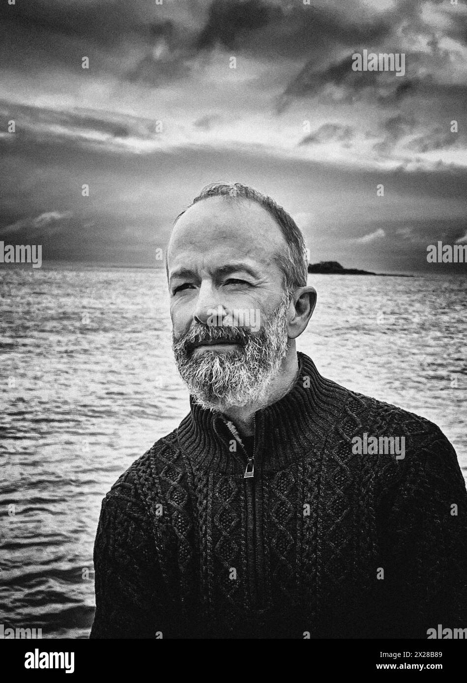 Kontemplativer Mann im mittleren Erwachsenenalter mit Bart auf dem Segelboot Stockfoto