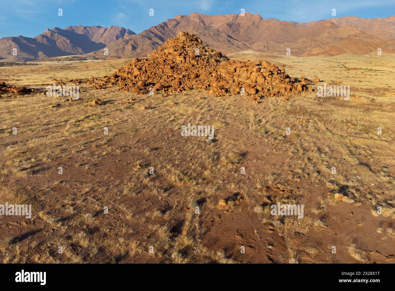 Malerische Wüstenlandschaft mit Felsen und trockenem Grasland, Brandberg, Namibia Stockfoto
