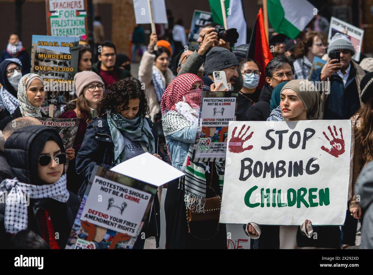 Chicago, USA, 20. April 2024, Pro Palestine Protester hält Stop Bombing Children Sign, während Demonstranten durch die Straßen der Innenstadt von Chicago marschieren, um gegen die israelische Besetzung des Gazastreifens zu protestieren. Joe Biden soll die US-Finanzierung Israels beenden und einen Waffenstillstand fordern, Credit: David Jank/Alamy Live News Stockfoto