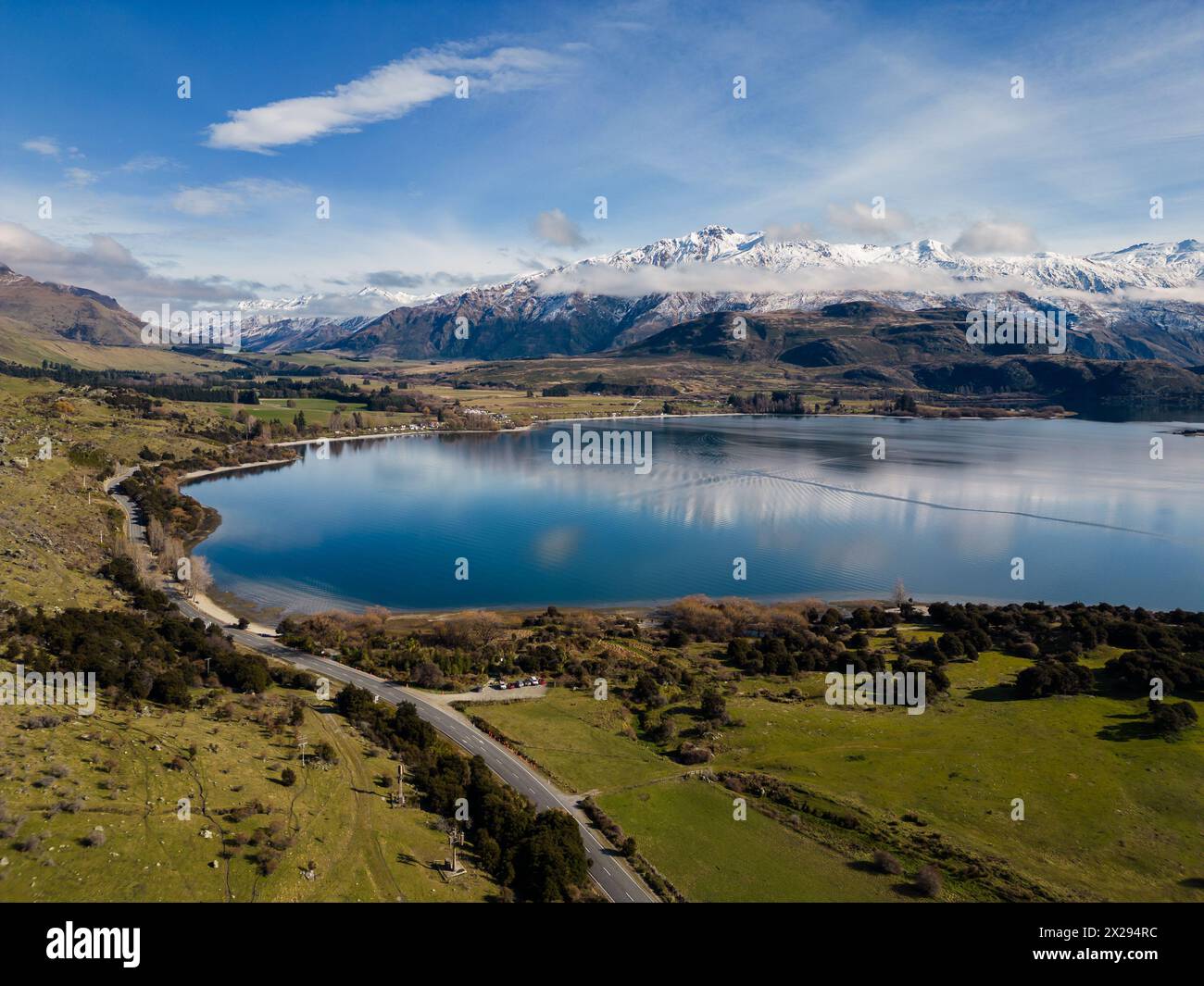 Wanaka, Neuseeland: Luftlinie der Glendhu Bay und Straße am See Wanaka mit dem schneebedeckten Mt, der auf der Südinsel Neuseelands aufstrebt. Stockfoto