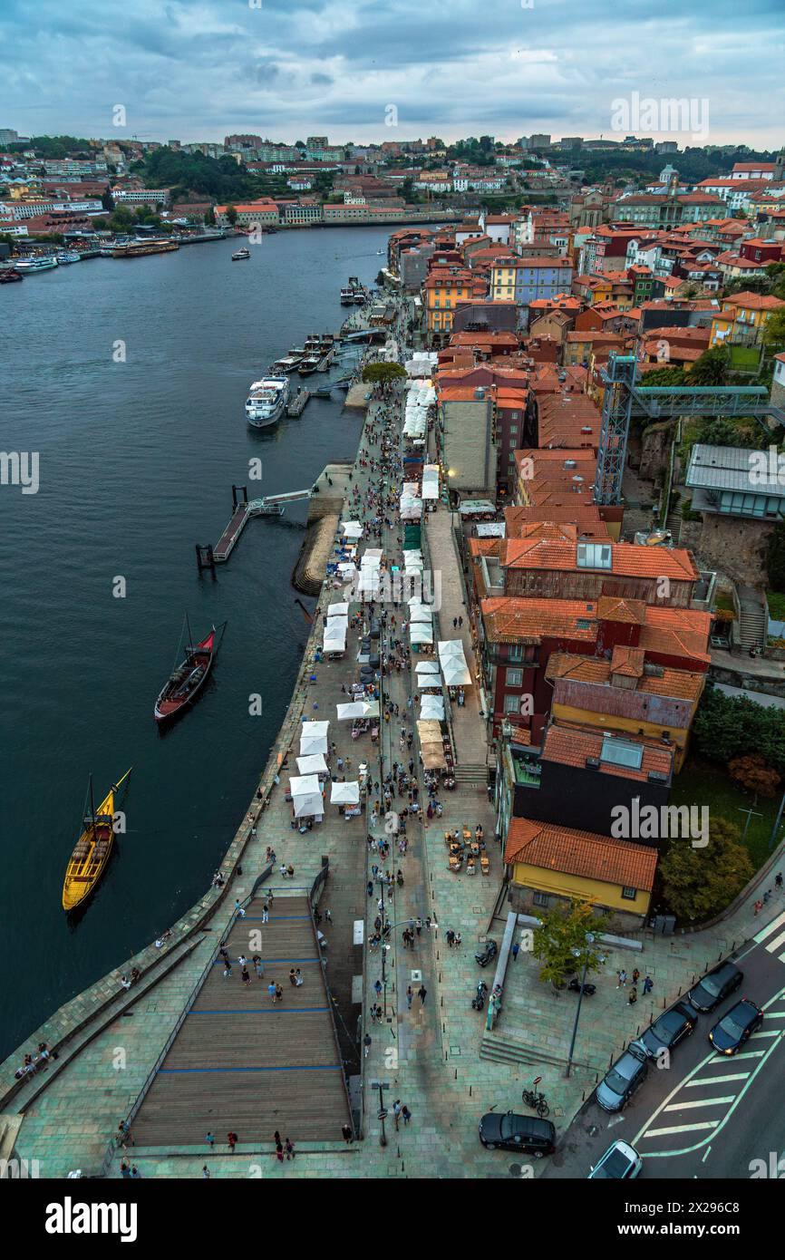 Blick von der Drohne auf den Fluss Douro und die Küste von Porto mit den alten Häusern und klassischen Booten am Dock; Restaurants und Touristen, die auf dem See spazieren Stockfoto