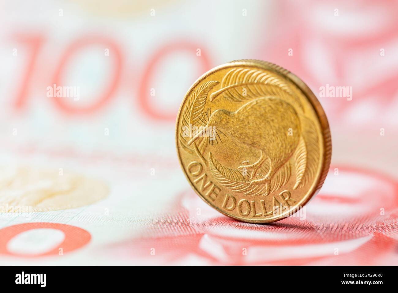 Neuseeland-Dollar, Finanzkonzept, 1-Dollar-Münze mit Kiwi auf dem Hintergrund von 100-Dollar-Banknoten Stockfoto
