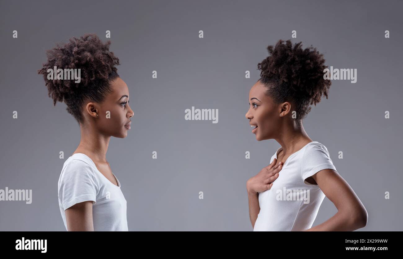 Introspektiver Konflikt erfasst: Schwarze Frau verachtet den Schock ihres Reflexions, eine selbstkontemplative Prüfung im Spiel Stockfoto