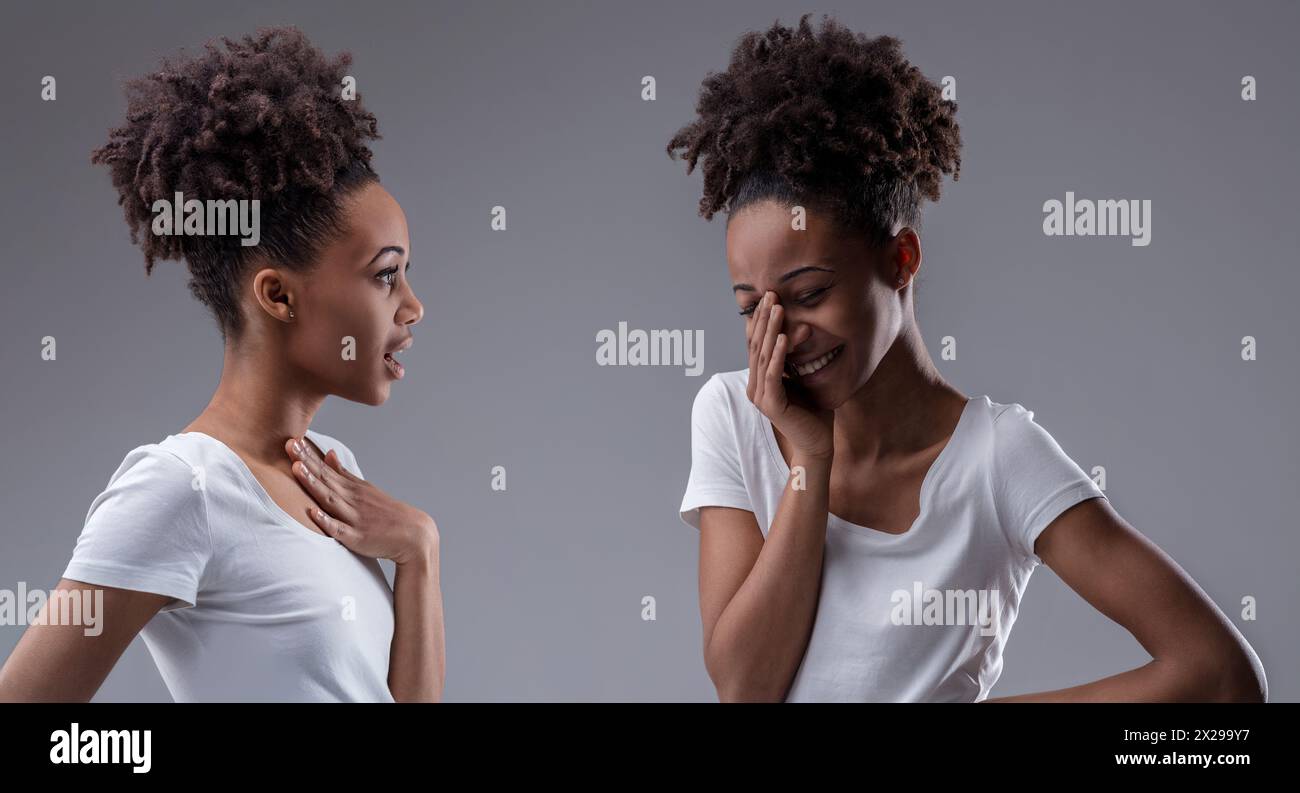 Schwarze Frau, die sich selbst tratscht, das Grinsen ihrer Reflexion zeigt Freude am gemeinsamen Geheimnis Stockfoto