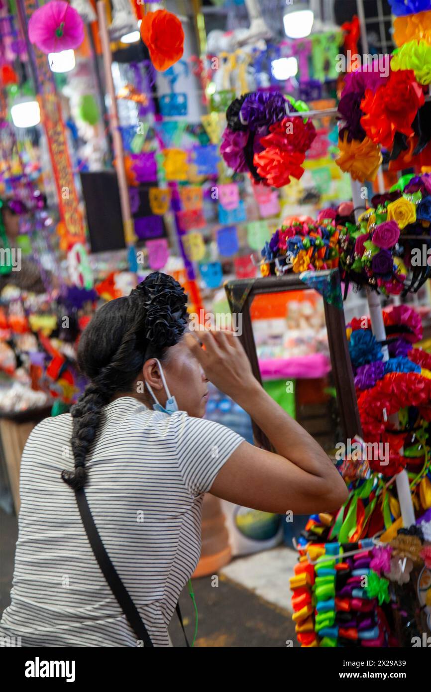 Frau versucht auf Haarband, Day of the Dead Paraphenalia auf dem Jamaica Markt in Mexico City, Mexiko Stockfoto