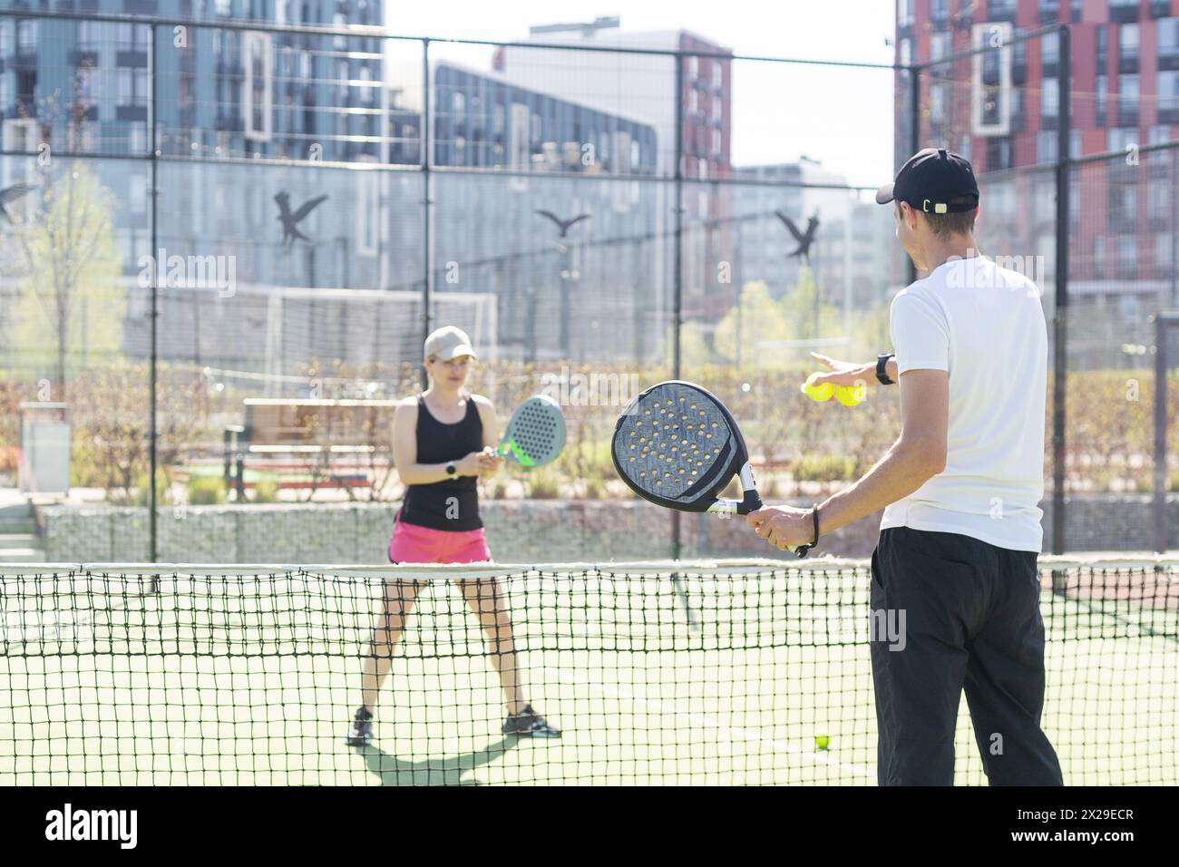 Sportpaare mit Padel-Schlägern, die auf dem Tennisplatz posieren Stockfoto