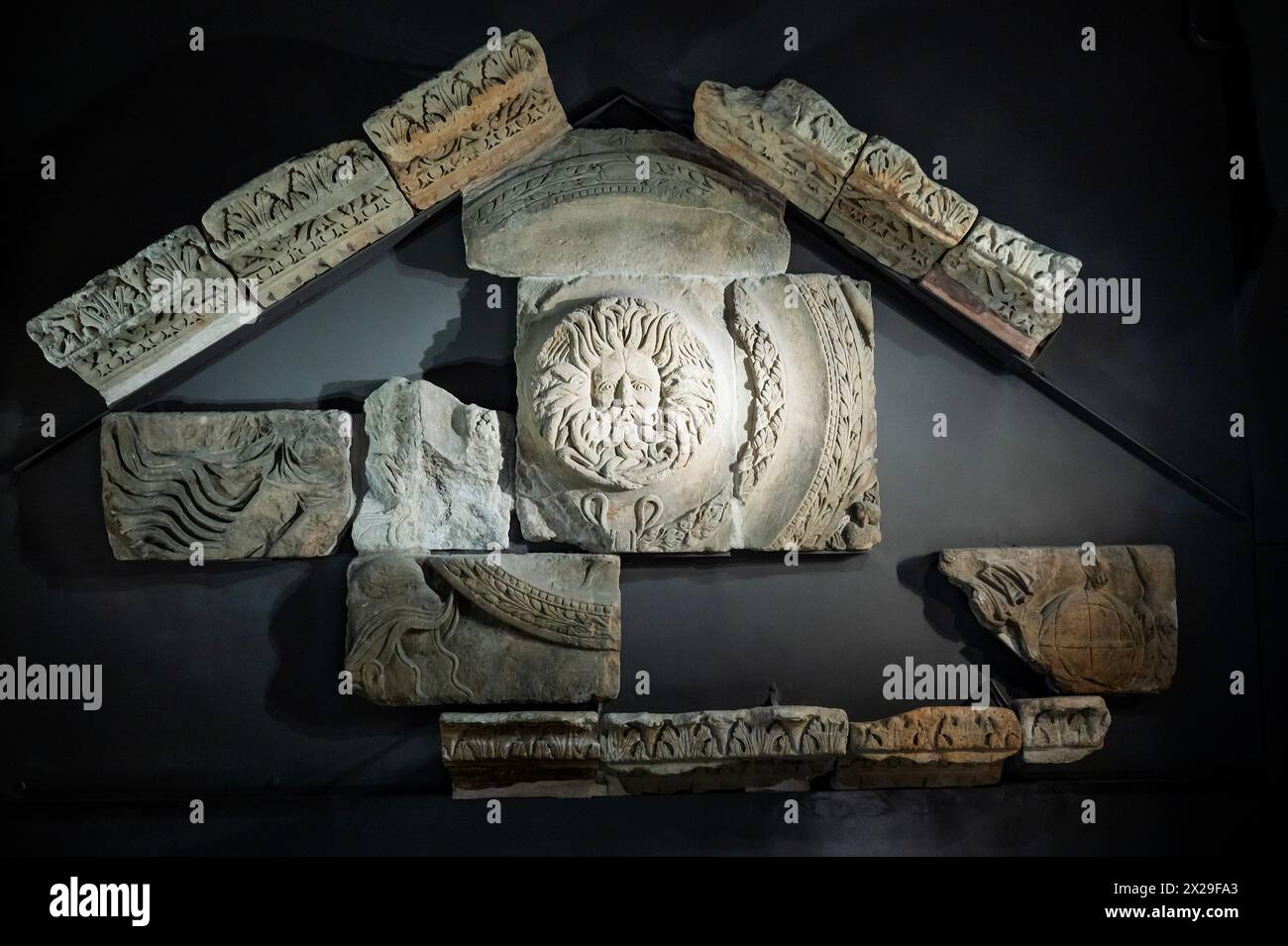 Bath, UK. April 2024. Tempelgiebel, die Vorderseite des Tempels für die Göttin Sulis Minerva, einer von nur zwei wirklich klassischen Tempeln aus dem römischen Großbritannien, mit einer Animation zeigt, wie der Giebel in römischer Zeit ausgesehen hätte. Es enthält den furchteinflößenden Kopf, der für die Gorgonen gehalten wird, der ein mächtiges Symbol der Göttin war. Besucher der Römischen Bäder genießen das Sommerwetter, während es kurz nach Bath zurückkehrt. Guy Bell/Alamy Live News Stockfoto