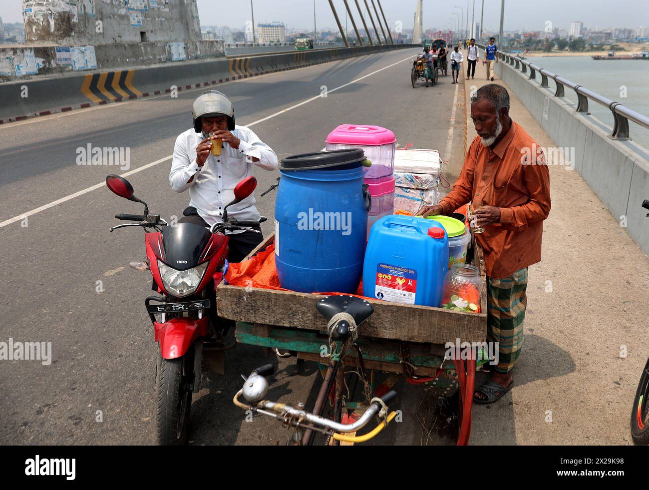 Chittagong, Karnaphuli, Bangladesch. April 2024. Das ganze Land leidet unter extremer Hitze. Fußgänger in der heißen Sonne auf der Shah Amanat Bridge in Chittagong, Bangladesch, finden Ruhe, indem sie mitten auf der Straße Wasser zur Verfügung stellen. Die anhaltende Hitzewelle im Land kann sich bis zum nächsten Montagmorgen 72 Stunden fortsetzen und die Temperatur kann weiter steigen. das Wetteramt hat eine 72-Stunden-Hitzewarnung im ganzen Land ausgegeben. Quelle: ZUMA Press, Inc./Alamy Live News Stockfoto