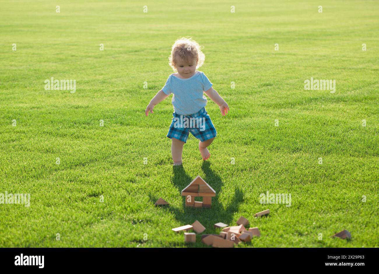 Versicherung Kinder. Baby spielen im grünen Gras. Entwicklung von Kindern. Stockfoto