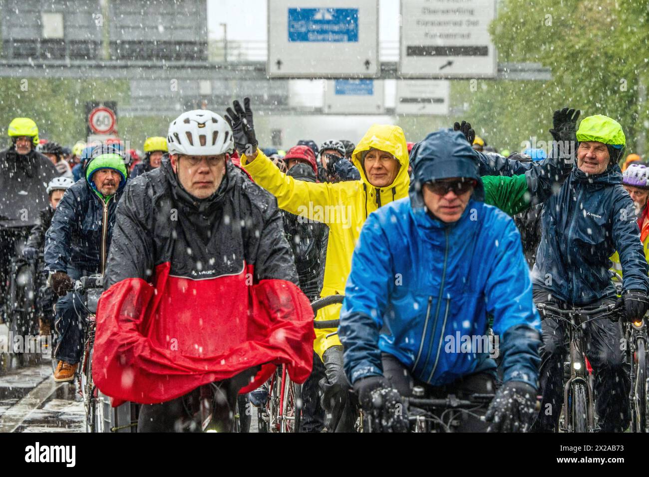 Rad-Sternfahrt des ADFC, Teilstück über die Autobahn A95, München, 21. April 2024 Deutschland, München, 21. April 2024, große Rad-Sternfahrt des ADFC, hier bei Schneefall auf der gesperrten Autobahn A 95 bei München-Sendling, alle in Regenjacken eingehüllt und durchnässt, fahren stadteinwärts Richtung Luise-Kiesselbach-Platz, kehren um und fahren auf der Gegenseite zurück Richtung Ausfahrt Kreuzhof, Fahrraddemo für die bessere Umsetzung des Radentscheids München , tausende Teilnehmer, Fahrrad-Demo, gemeinsam Radeln für eine bessere Radinfrastruktur, Teilstück über die A95, Verkehr, Fahrrad fah Stockfoto