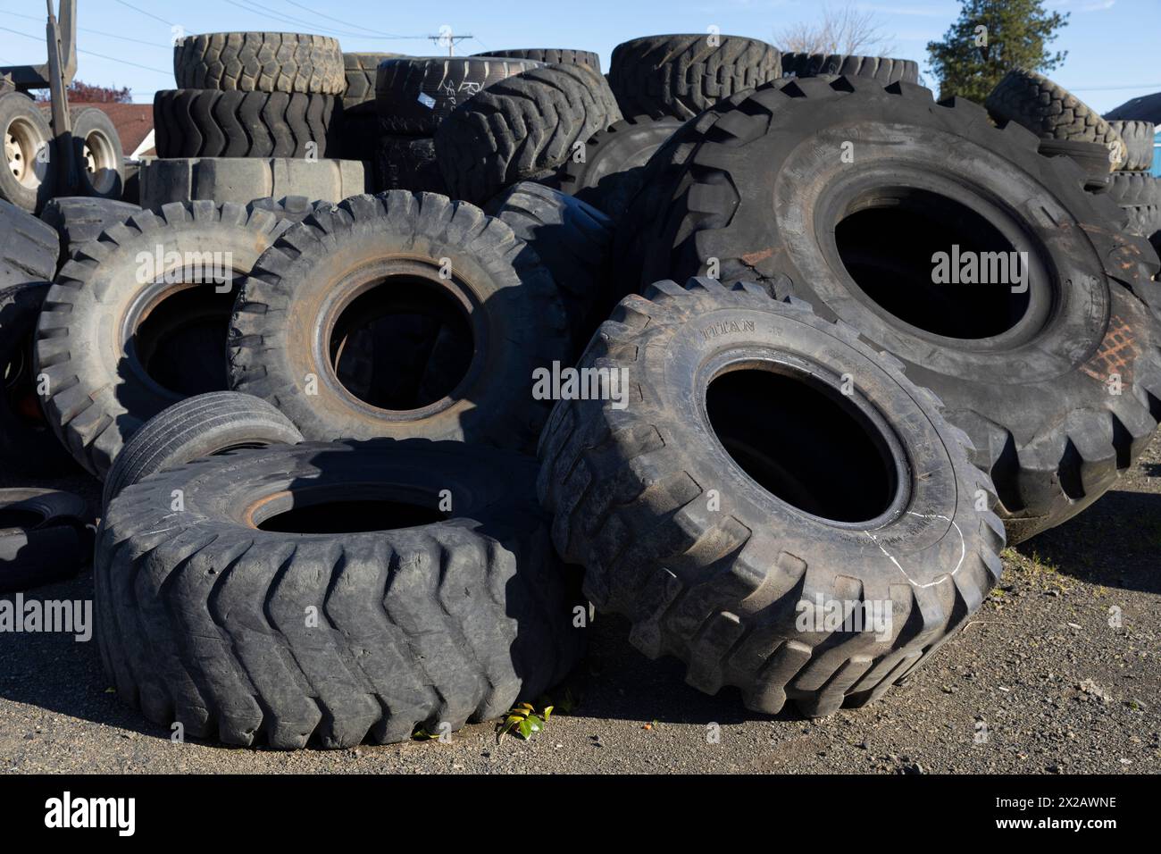 Entsorgte Traktorreifen füllen eine leere Partie in einer Reifenwerkstatt in Aberdeen, Washington. Stockfoto