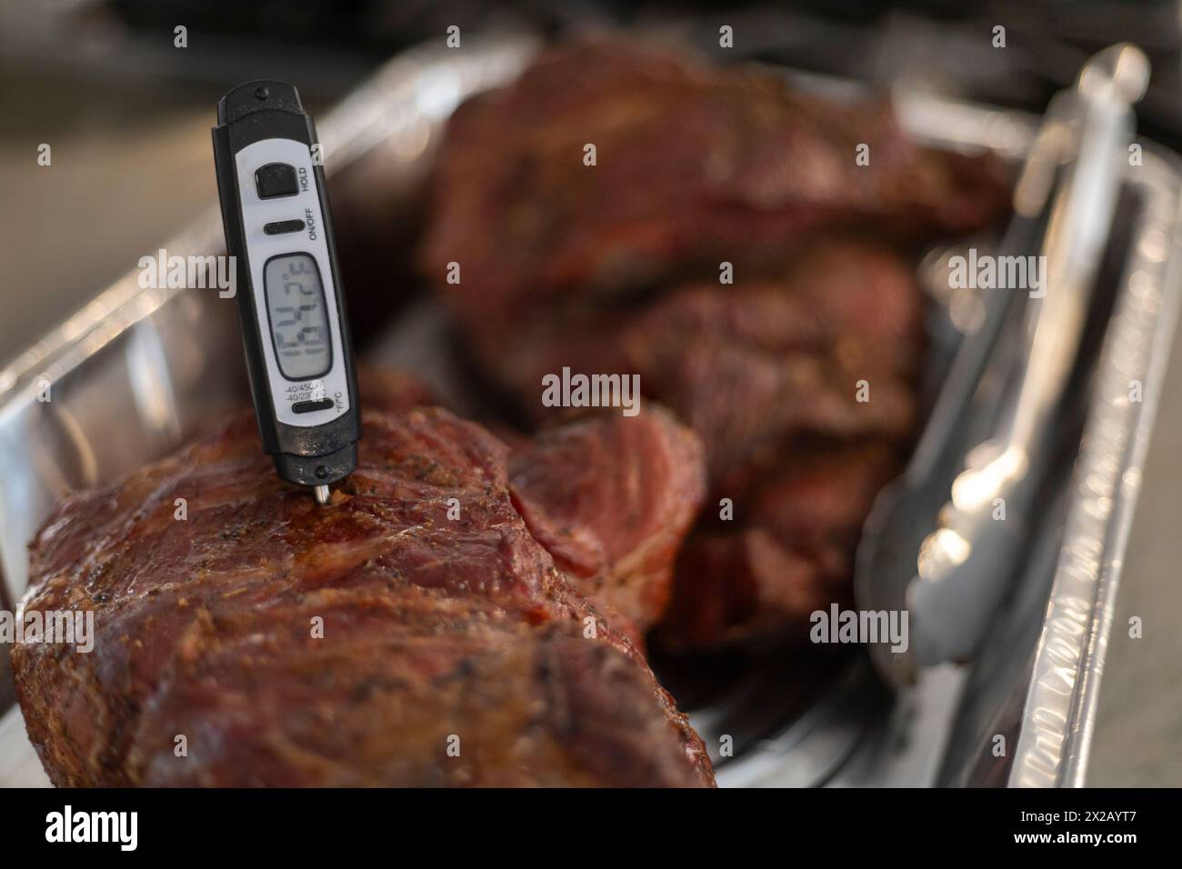 BBQ, Schweinebraten auf Grill und Raucher zubereitet. Temperaturmessung Stockfoto