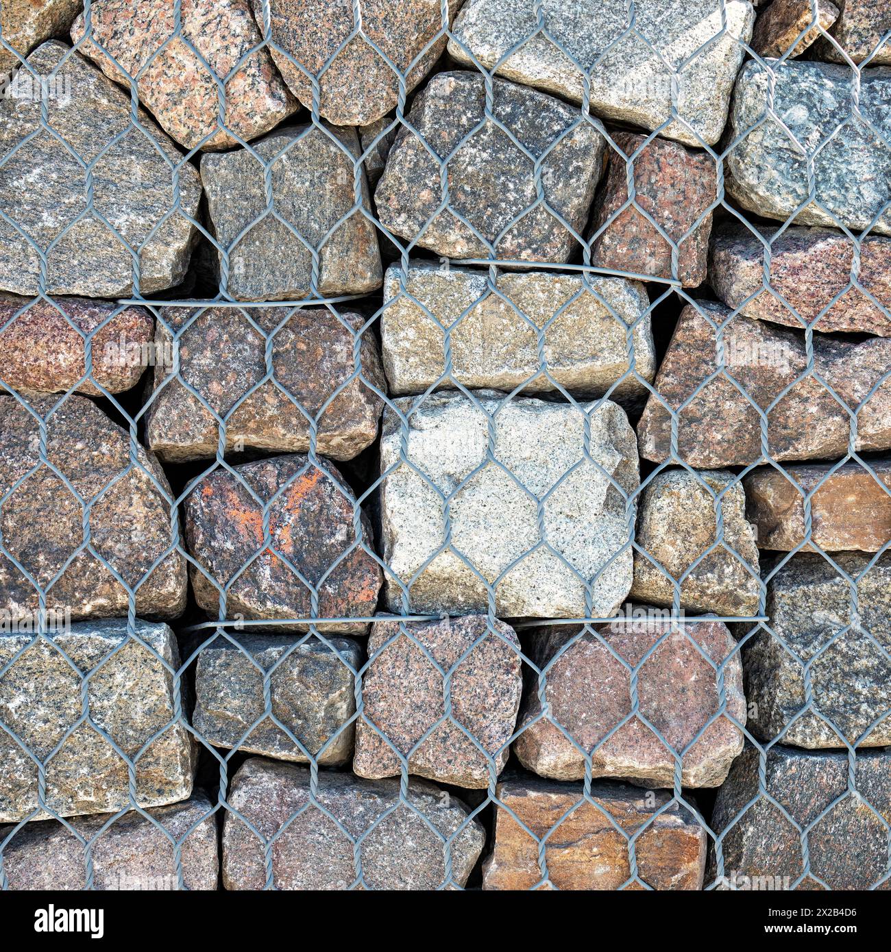 Hauszaun - Stahl durchbrochener Steinzaun - Gabion - Stahl verzinkte Netze gefüllt mit Spaltstein. Moderne dekorative Elemente des Landschaftsdesigns Stockfoto
