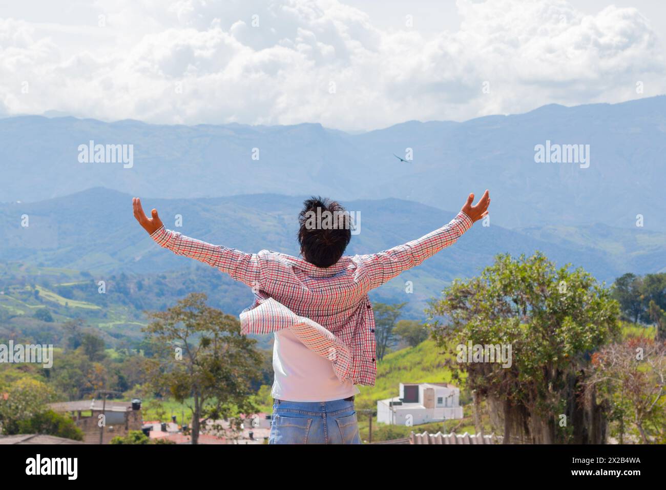 Lifestyle. Junger lateinischer Mann mit ausgestreckten Händen, der die Landschaft genießt. Rückansicht Stockfoto