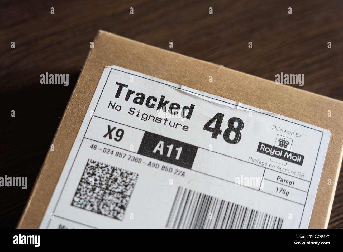 Eine 48-Stunden-Kartonverpackung mit einem Barcode und einem QR-Code auf dem Papieretikett von Royal Mail verfolgte No Signature. Konzept: QR-Codes, Poststreik Stockfoto