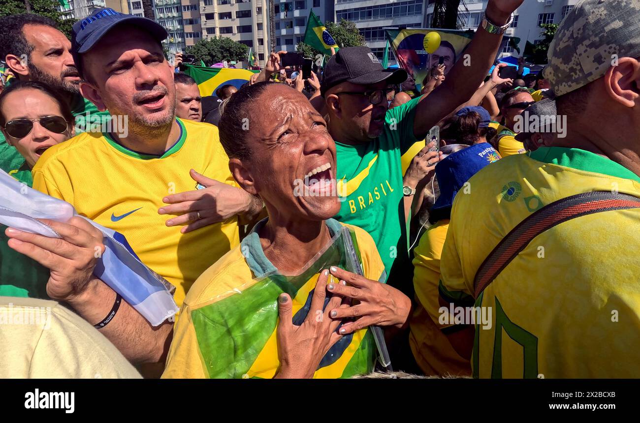 Rio de Janeiro, Brasilien. 21. April 2024, Rio de Janeiro, Rio de Janeiro, Brasilien: Eine Frau klammert die brasilianische Flagge während des Gesangs der Nationalhymne. Zehntausende kamen am Sonntag an Rios berühmten Copacabana-Strand, als Brasiliens Ex-Präsident JAIR BOLSONARO zu einer Massendemonstration aufrief, um die Stärke seiner Unterstützung zu unterstreichen. Der Protest wurde von Bolsonaro im Rahmen von Ermittlungen einberufen, bei denen er das Ziel einer mutmaßlichen Beteiligung an einem versuchten Staatsstreich ist, um an der Macht zu bleiben. Quelle: ZUMA Press, Inc./Alamy Live News Stockfoto