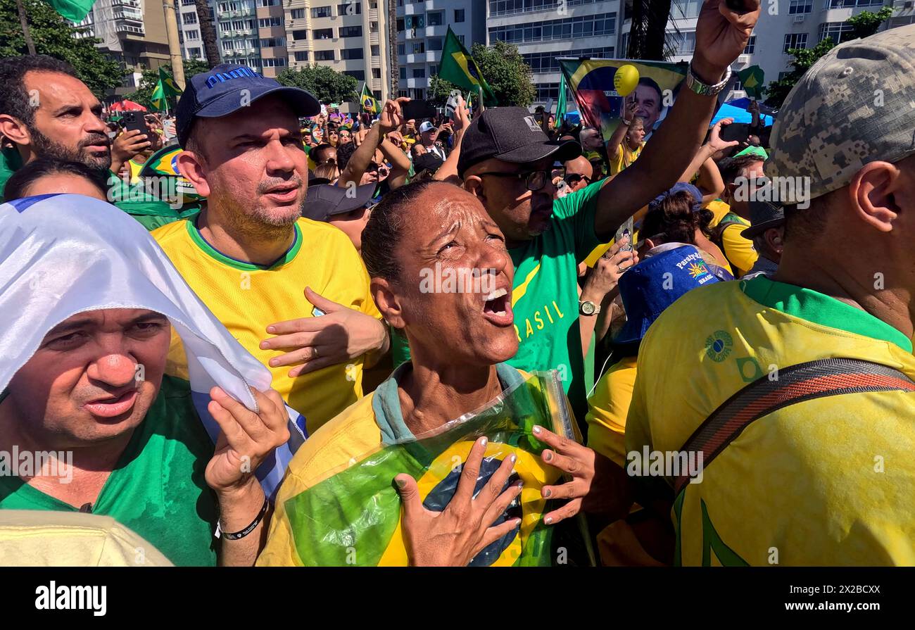 Rio de Janeiro, Brasilien. 21. April 2024, Rio de Janeiro, Rio de Janeiro, Brasilien: Eine Frau klammert die brasilianische Flagge während des Gesangs der Nationalhymne. Zehntausende kamen am Sonntag an Rios berühmten Copacabana-Strand, als Brasiliens Ex-Präsident JAIR BOLSONARO zu einer Massendemonstration aufrief, um die Stärke seiner Unterstützung zu unterstreichen. Der Protest wurde von Bolsonaro im Rahmen von Ermittlungen einberufen, bei denen er das Ziel einer mutmaßlichen Beteiligung an einem versuchten Staatsstreich ist, um an der Macht zu bleiben. Quelle: ZUMA Press, Inc./Alamy Live News Stockfoto