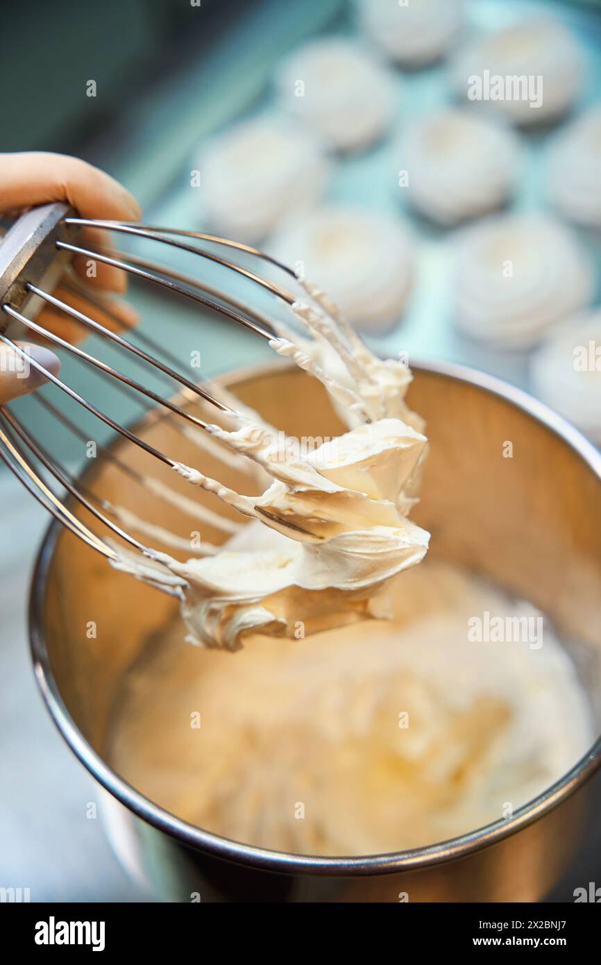 Professionelle Bäckerin, die Fruchtpüree mit anderen Zutaten schlägt Stockfoto