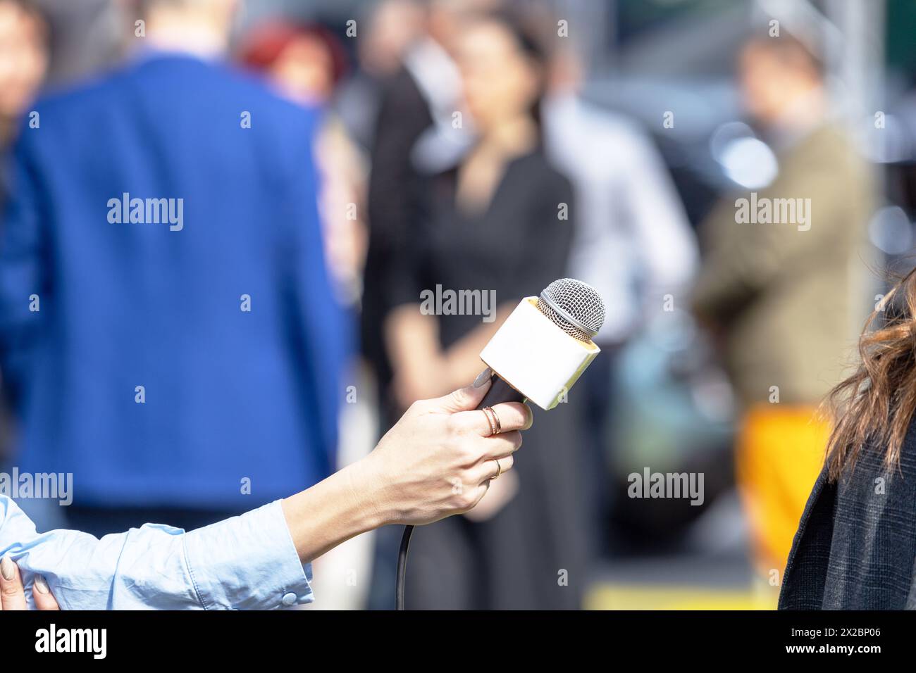 Reporterin, die ein Medieninterview mit einer nicht erkennbaren weiblichen Person führt Stockfoto