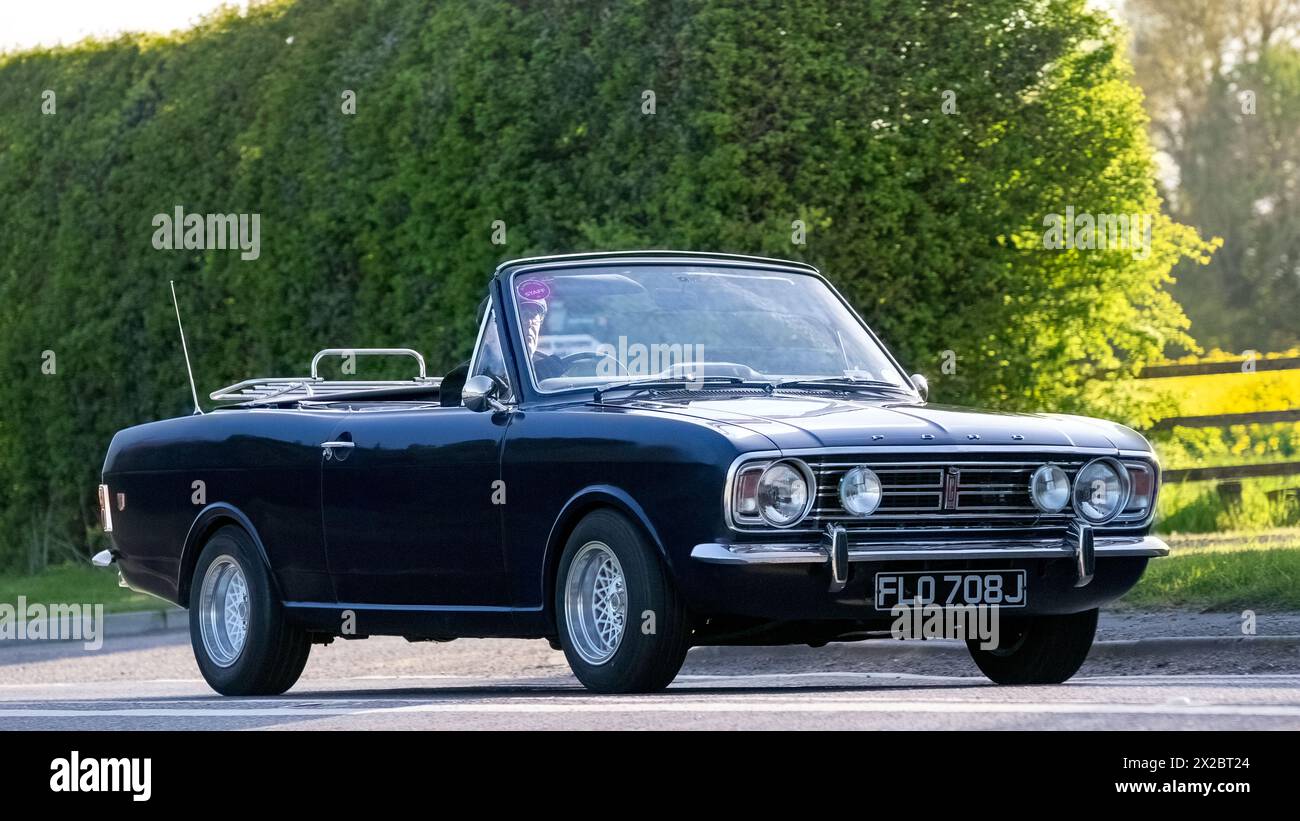 Bicester, UK - 21. April 2024: 1970 blaues Cabriolet Ford Cortina Oldtimer fährt auf einer britischen Straße Stockfoto