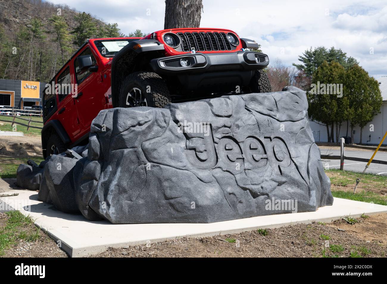 Ein knallroter Jeep Wrangler Sport-Nutzfahrzeug, der auf einem gefertigten Felsen bei Krystal Chrysler Jeep Dodge RAM Fiat in Warrensburg, NY, geparkt wurde Stockfoto Ein knallroter Jeep Wrangler Sport-Nutzfahrzeug, der auf einem gefertigten Felsen bei Krystal Chrysler Jeep Dodge RAM Fiat in Warrensburg, NY, geparkt wurde Stockfoto