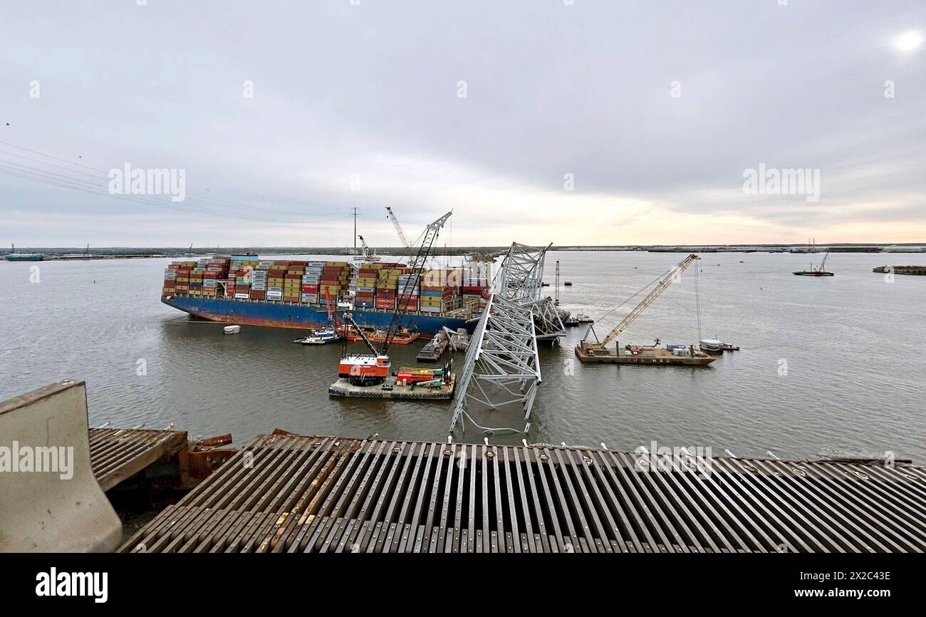 Dundalk, Vereinigte Staaten Von Amerika. April 2024. Dundalk, Vereinigte Staaten von Amerika. April 2024. Krankähne heben Wrackteile der eingestürzten Francis Scott Key Bridge vom MV Dali Containerschiff ab, während die Arbeiten zur Eröffnung des Fort McHenry Kanals am 21. April 2024 in der Nähe von Dundalk, Maryland, fortgesetzt werden. Die Brücke wurde am 26. März von einem 984-Fuß-Containerschiff getroffen und stürzte zusammen, wobei sechs Arbeiter ums Leben kamen. Quelle: PO3 Erin Cox/USA Coast Guard Photo/Alamy Live News Stockfoto