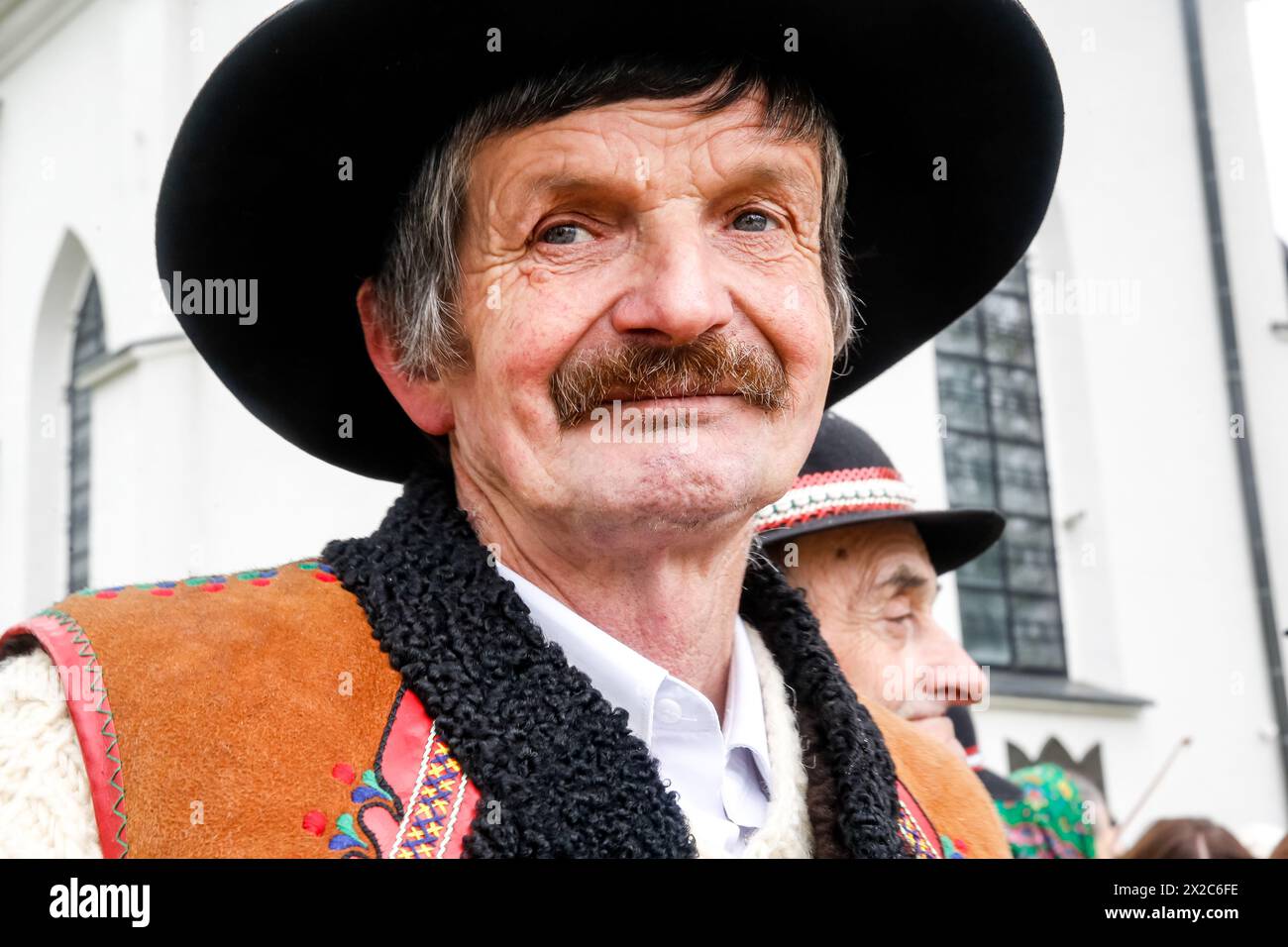 Ein Hochlander-Hirte wird in seinen traditionellen Kleidern gesehen, während die Weidezeit mit traditionellen Folklore- und religiösen Feiern beginnt, die lokal Redyk genannt werden, in den Tatra-Bergen. Redyk beginnt traditionell um den 23. April, eine Zeit, in der Schafhirten, die lokal Baca genannt werden, Schafherden aus Dörfern aufwärts nehmen, weg von der Zivilisation für die etwa ein halbes Jahr dauernde Weidezeit. Der Saisonbeginn ist eine festliche Zeit für die Bergwanderer aus Tatra. Und dieser Teil von Karpaty als Schafzucht ist historisch gesehen eine wichtige Einkommensquelle für die Region. Stockfoto