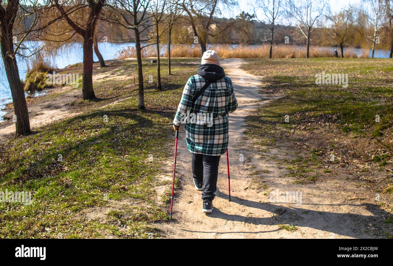 Nordic Walking Frau am See im Frühling Stockfoto