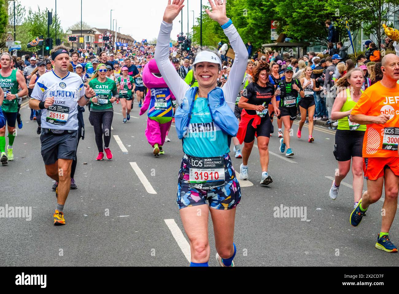 Die Läuferin spreizt ihre Arme, während sie beim London Marathon 2024 posiert Stockfoto