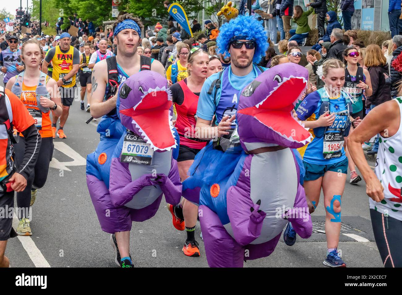 London Marathon 2024: Zwei Läufer in aufblasbaren T-Rex Dinosaurier Kostümen auf der Route des 44. London Marathon. Stockfoto