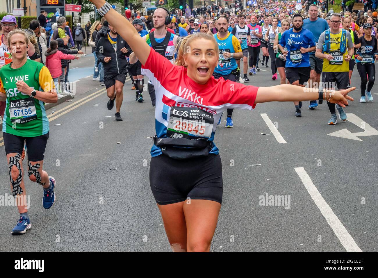 Läuferin posiert zum Fotografieren auf der Route des London Marathon 2024 Stockfoto
