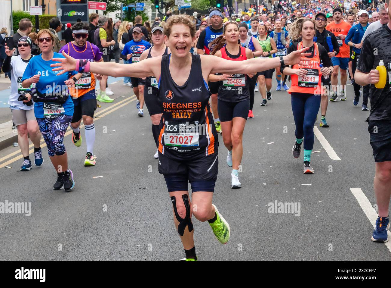 Die Läuferin spreizt ihre Arme weit, während sie beim London Marathon 2024 posiert Stockfoto