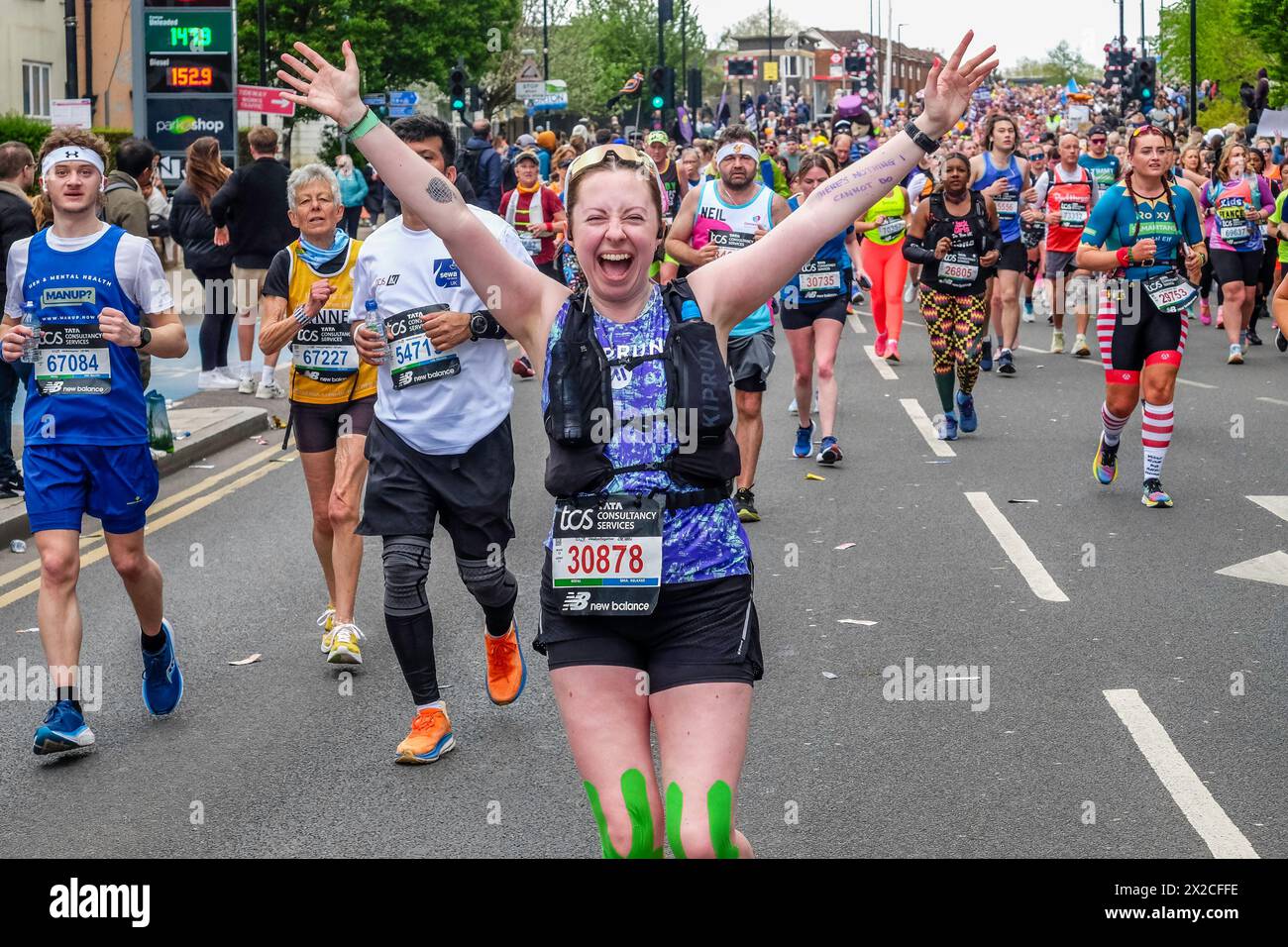 Die Läuferin spreizt ihre Arme vor Freude, während sie beim London Marathon 2024 posiert Stockfoto