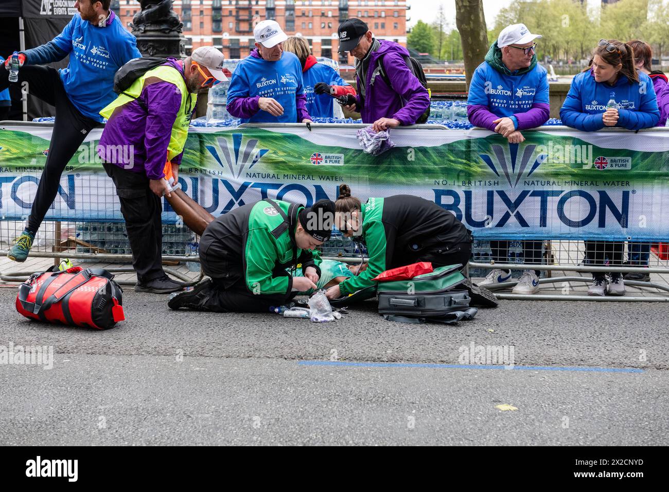 London, Großbritannien. April 2024. Milkesa Mengesha stürzt bei 39 km ein und wird von Freiwilligen und Mitarbeitern für St. John's Ambulance unterstützt. Milkesa Mengesha aus Äthiopien tritt beim Männer-Elite-Rennen während des TCS London Marathon 2024 am 21. April in England an Credit: GUE Studios/Alamy Live News Stockfoto