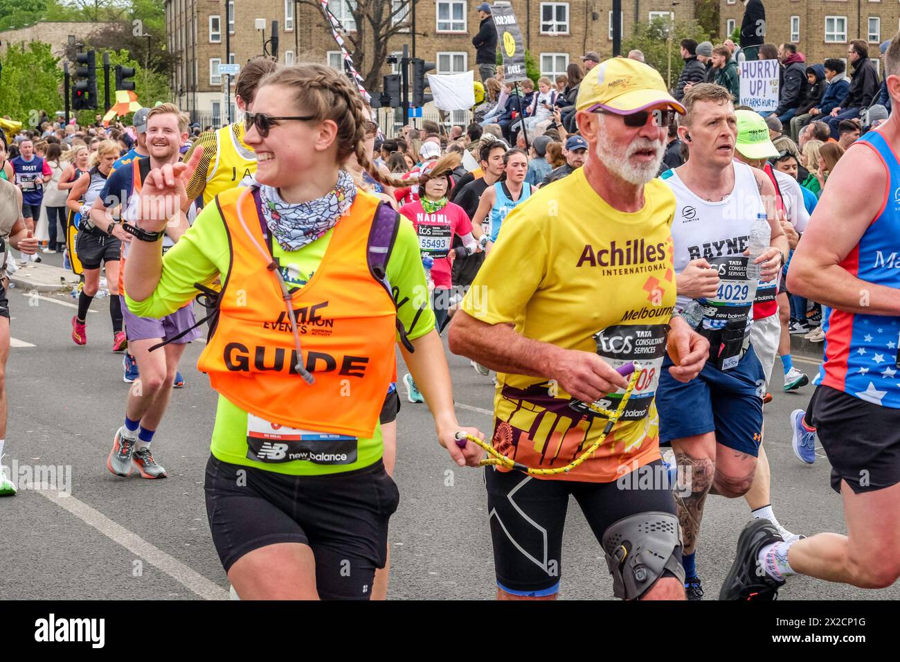 London Marathon 2024: Sehbehinderte Läufer und Reiseleiter laufen gemeinsam auf der Strecke des London Marathon. Stockfoto