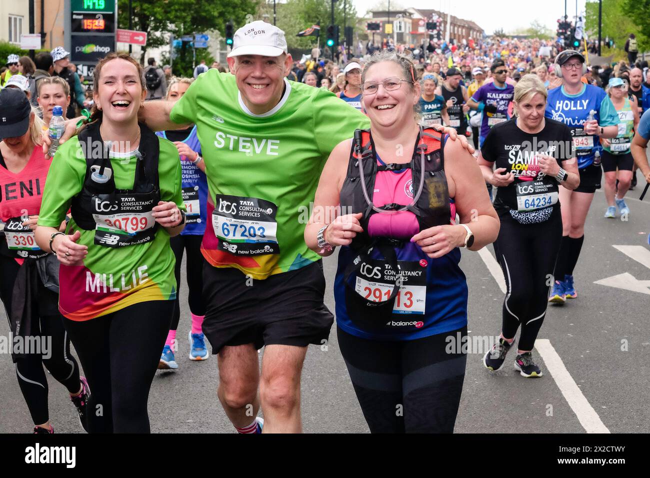 London Marathon 2024: Drei Läufer halten an, um vor der Kamera zu posieren. Stockfoto