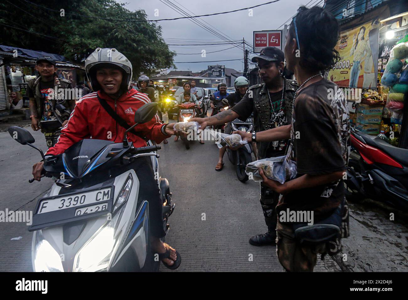 Mitglieder der Punk-Community in Bogor, West Java, Indonesien, geben Straßenbenutzern am 31. März 2024 Nahrung Stockfoto