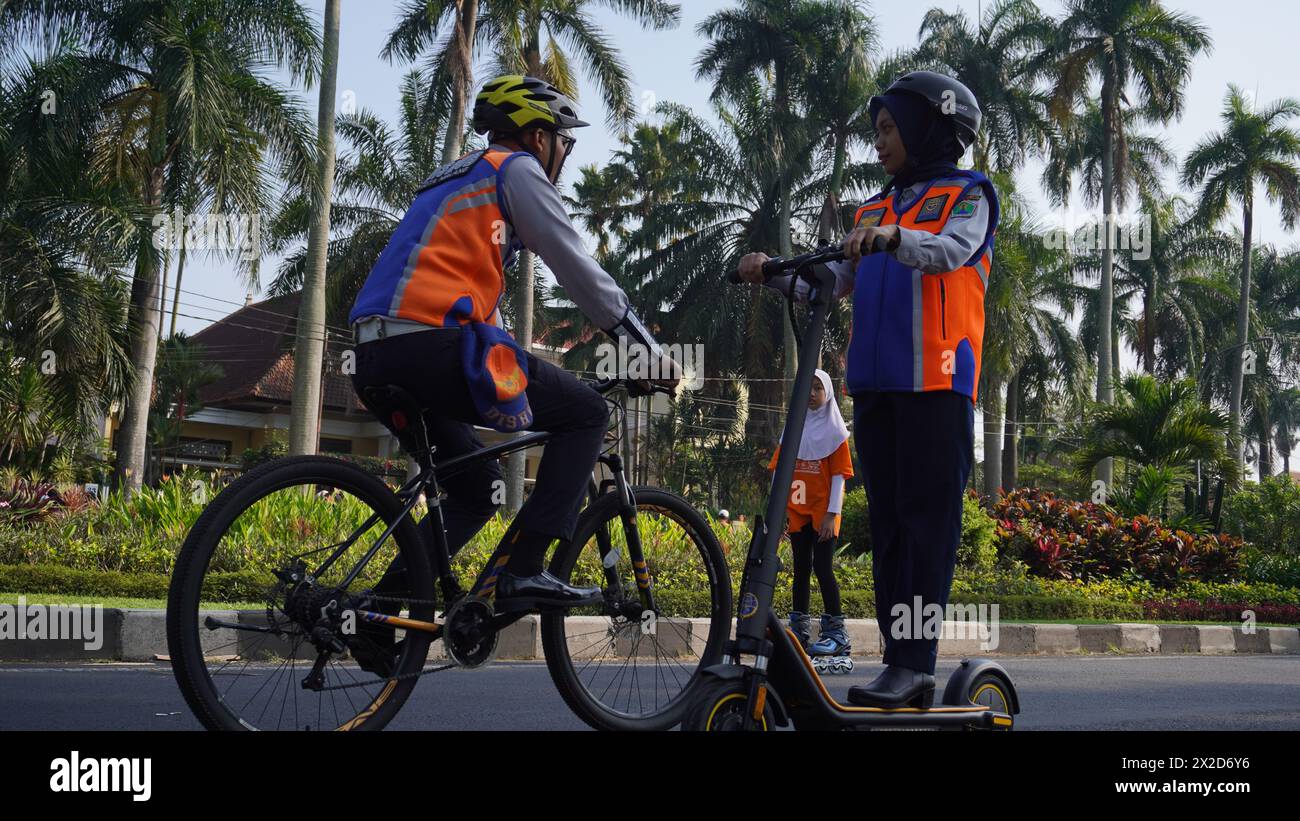 Transportdienstmitarbeiter, die den Bereich Malang Car Free Day beaufsichtigen, verwenden Elektroroller und Fahrräder Stockfoto