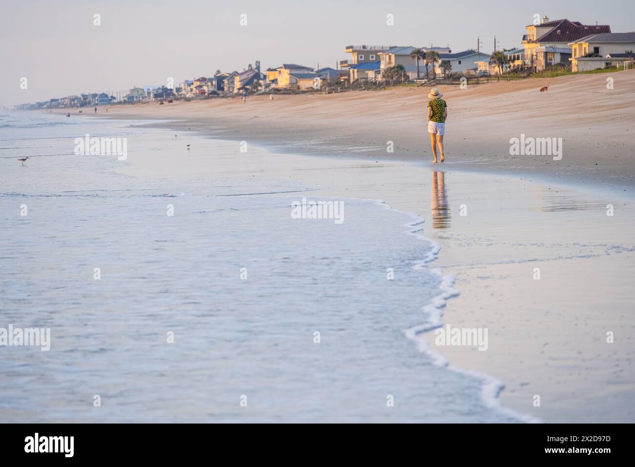 Frau, die bei Sonnenaufgang entlang der Küste am South Ponte Vedra Beach im Nordosten Floridas spaziert. (USA) Stockfoto