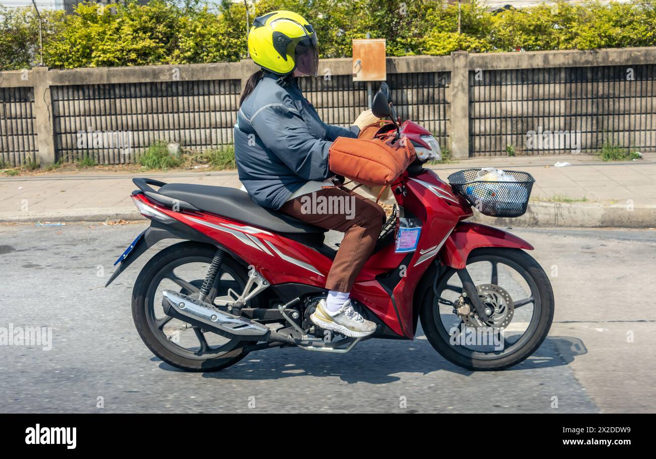 Eine Frau fährt Motorrad mit Schutzhandschuhen, Thailand Stockfoto