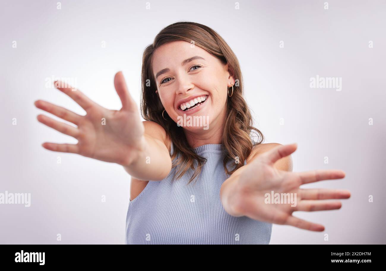 Hände, Portrait und Lächeln mit aufgeregter Frau im Studio auf weißem Hintergrund für Emotionen oder Ausdruck. Emoji, Gesicht und Geste mit glücklicher Person Stockfoto