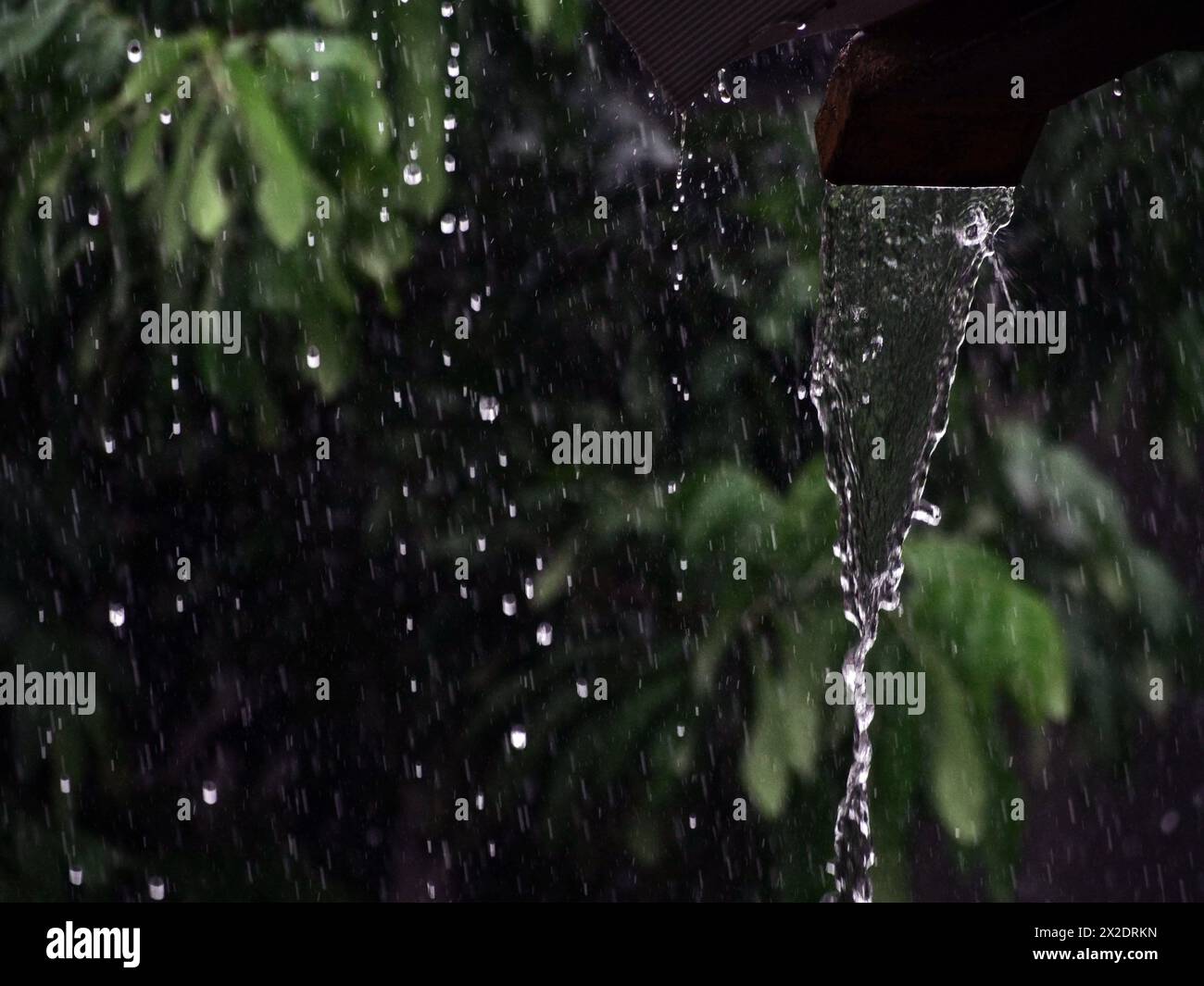 Regenwasser fließt aus der Rinne. Selektiver Fokus Stockfoto